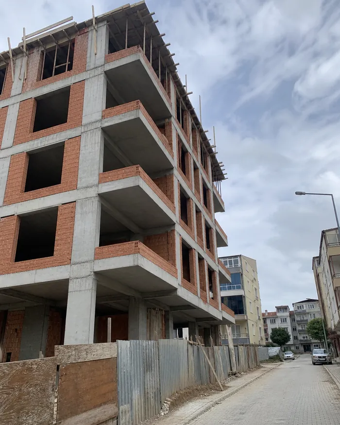 Yapım aşamasındaki apartman ve tuğla duvarlar